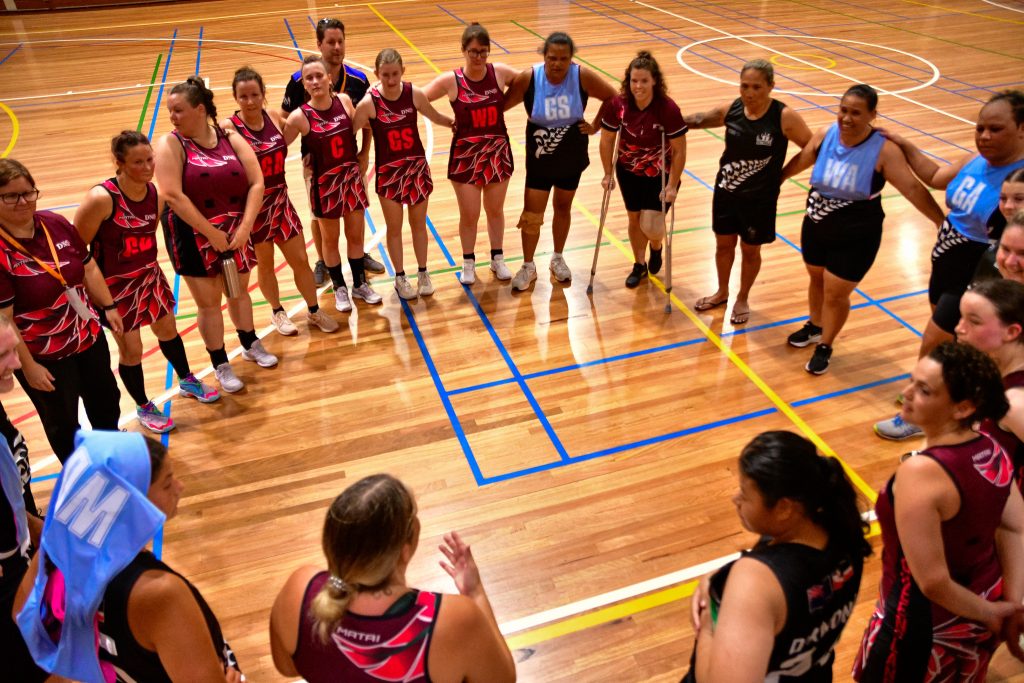 Queensland and New Zealand netball players gather together post match at the Australian Deaf Games. Image: Simon Leonard